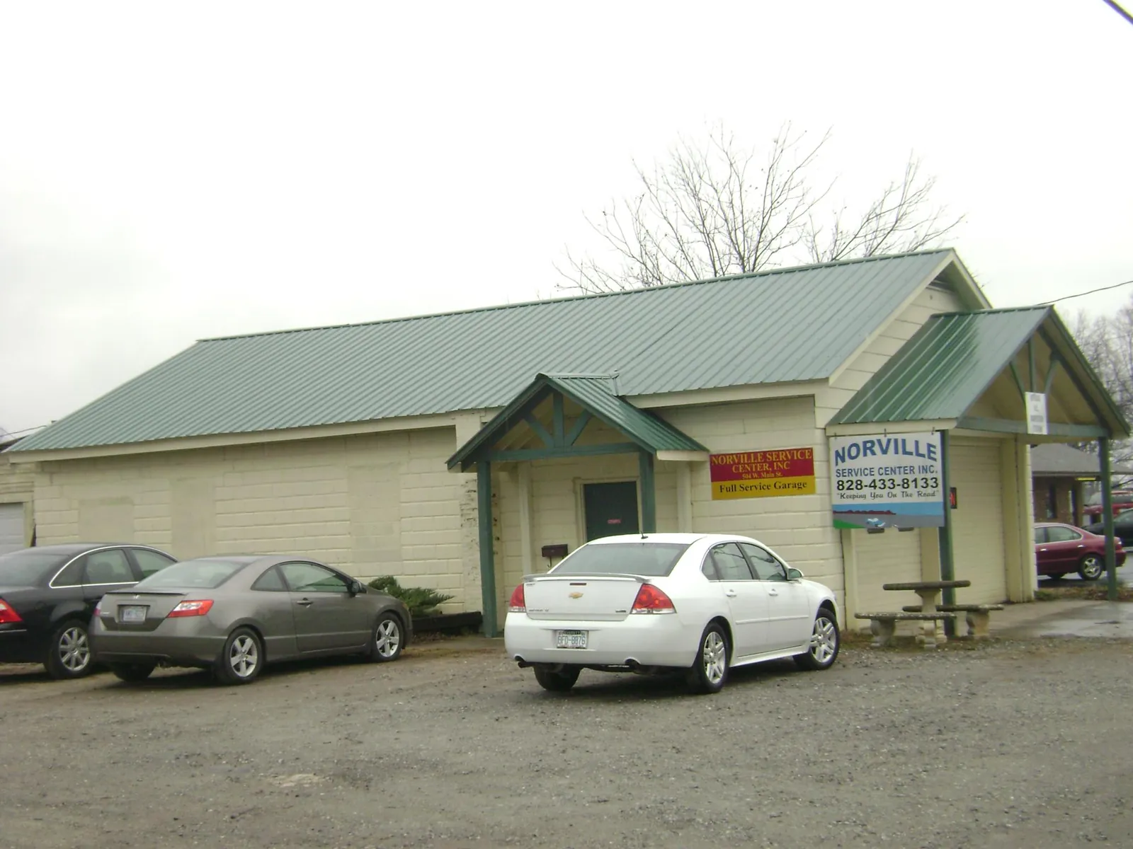 Green metal roof on a service garage with a covered entry in Hopkinton