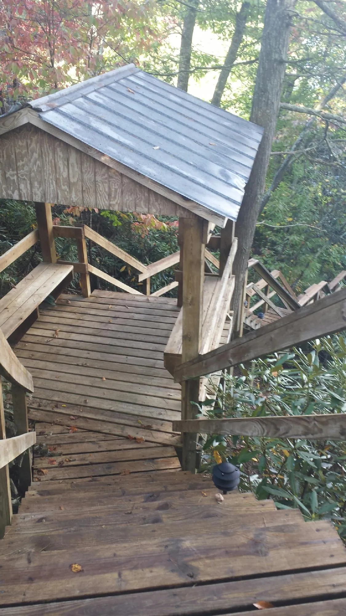 Metal roofed shelter over wooden steps on a wooded walkway — Skylight Repair & Installation work by our crew in Hopkinton